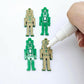 40mm nutcracker Christmas dangle blanks with engraved paint-fill details shown in  green acrylic with white posca paint pen painting a piece
