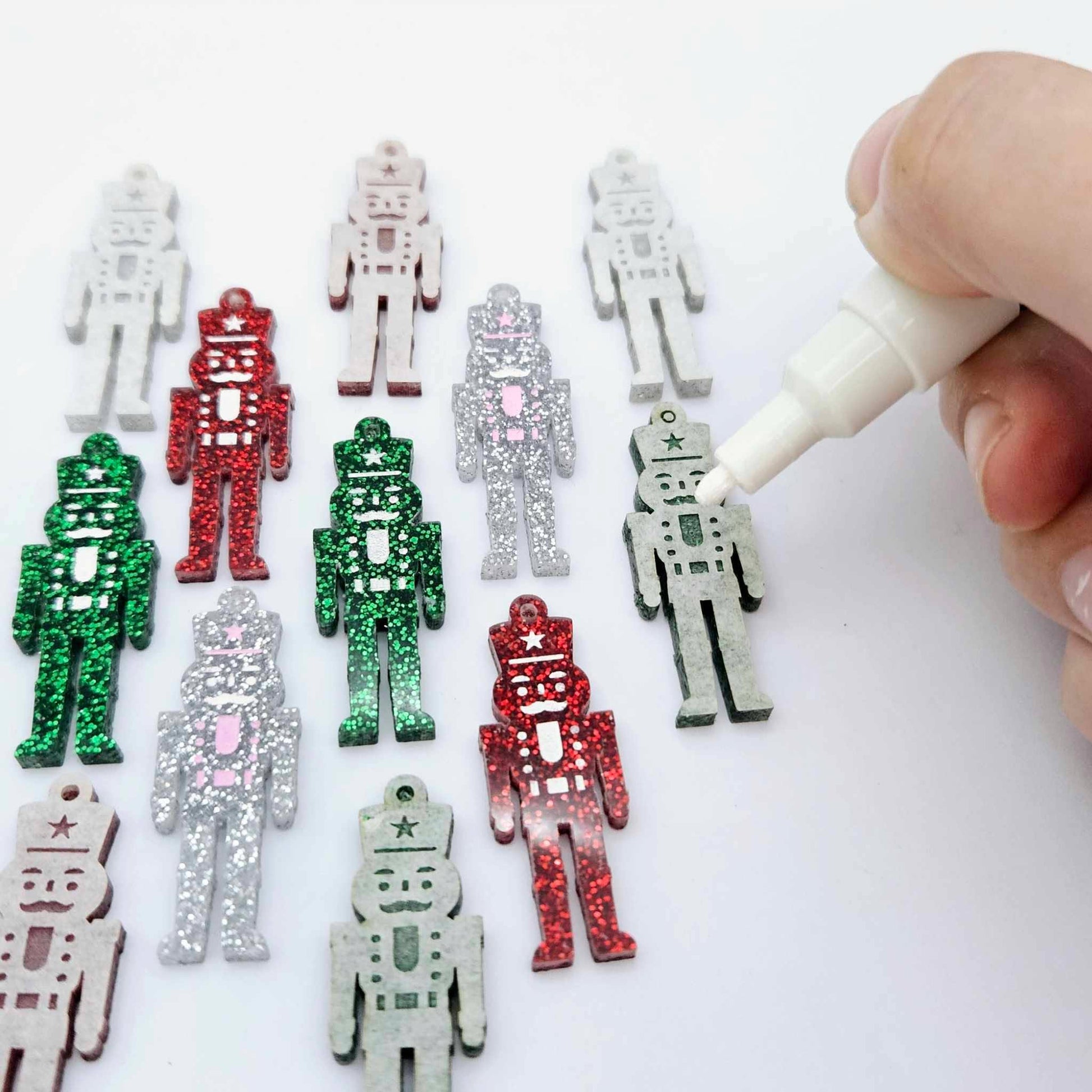 40mm nutcracker Christmas dangle blanks with engraved paint-fill details shown in green, red and silver glitter acrylic