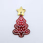 One deep red marble cookie Christmas tree dangle with engraved icing details paint filled in light pink and white, assembled with a 16mm gold mirror star topper
