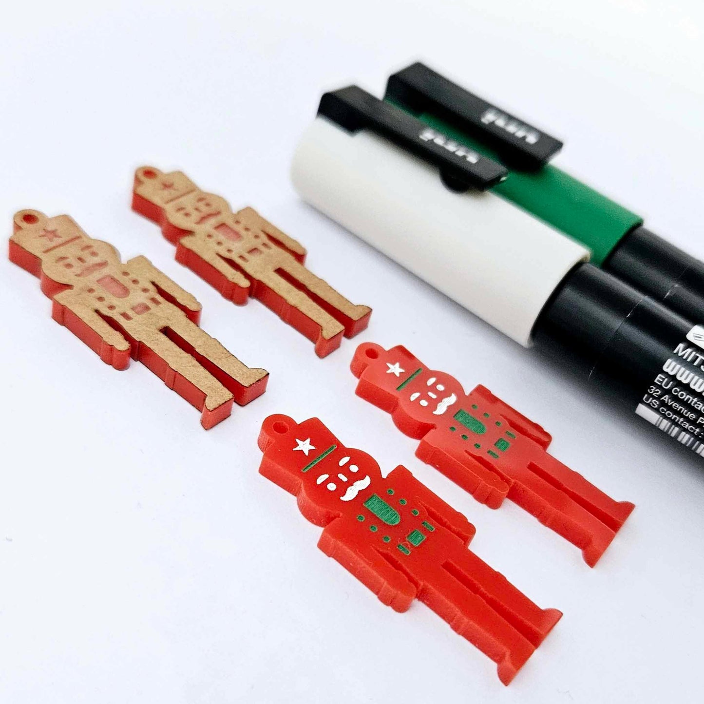 40mm nutcracker Christmas dangle blanks with engraved paint-fill details shown in  red acrylic with green and white posca paint pens