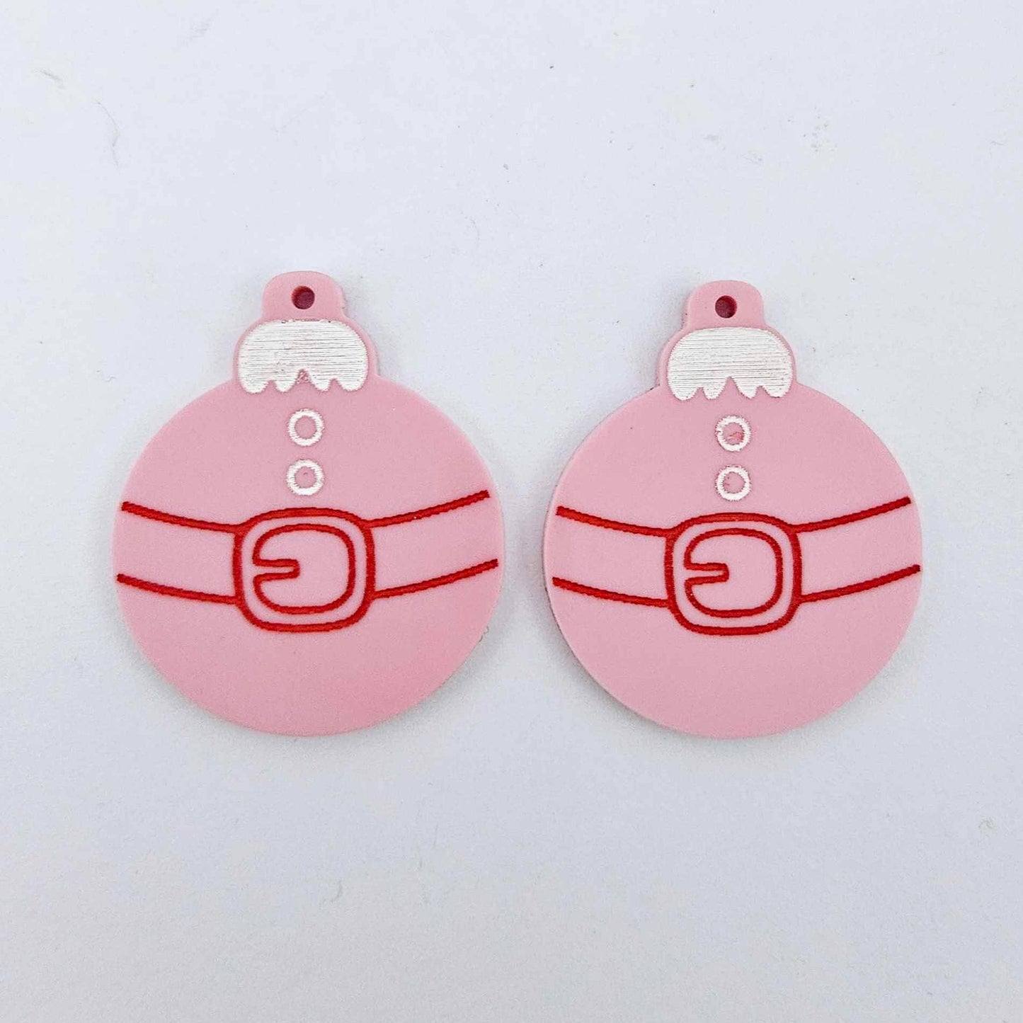 One pair of pastel pink Santa bauble dangle blanks with engraved Santa belt and button details paint filled in white and red, shown laying flat