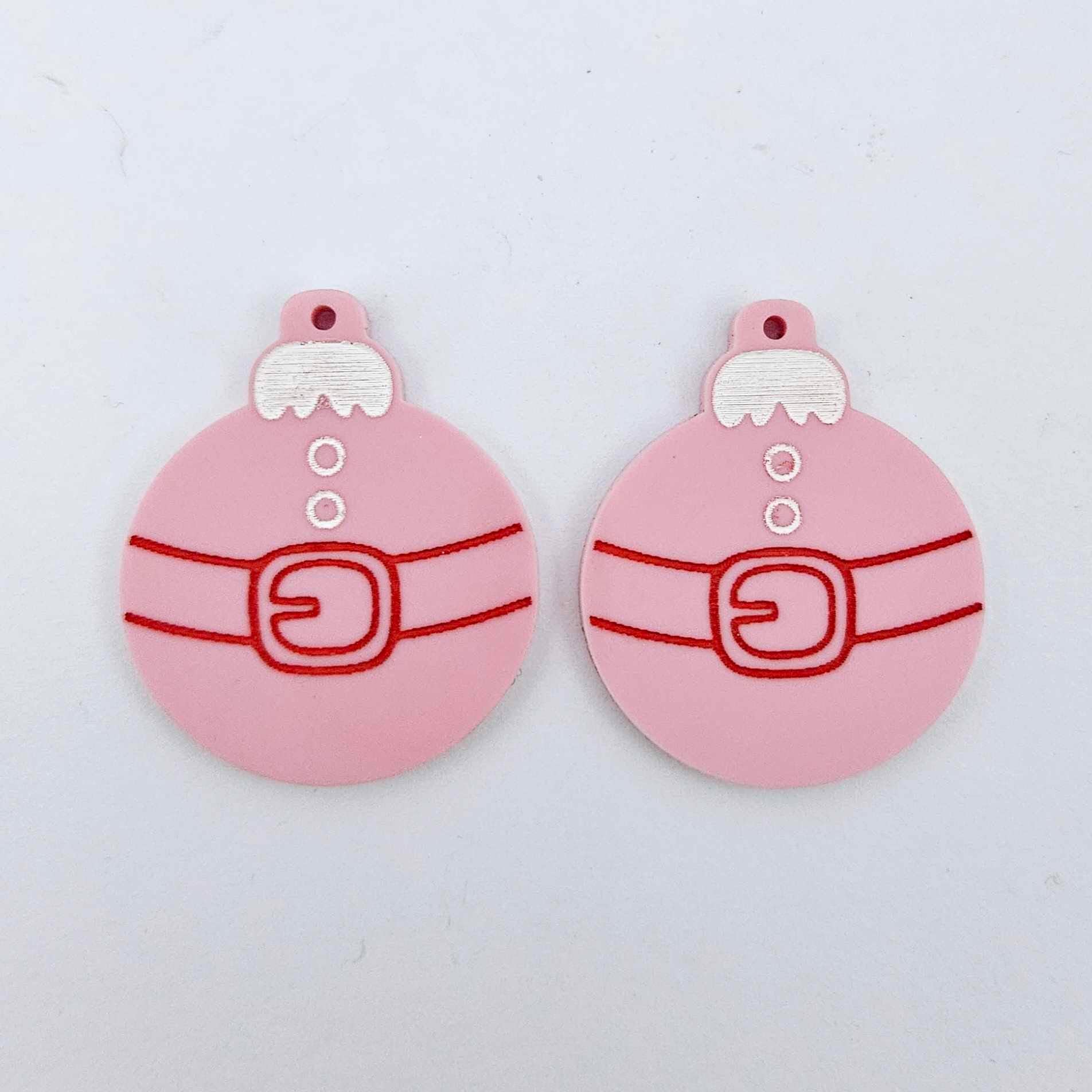 One pair of pastel pink Santa bauble dangle blanks with engraved Santa belt and button details paint filled in white and red, shown laying flat