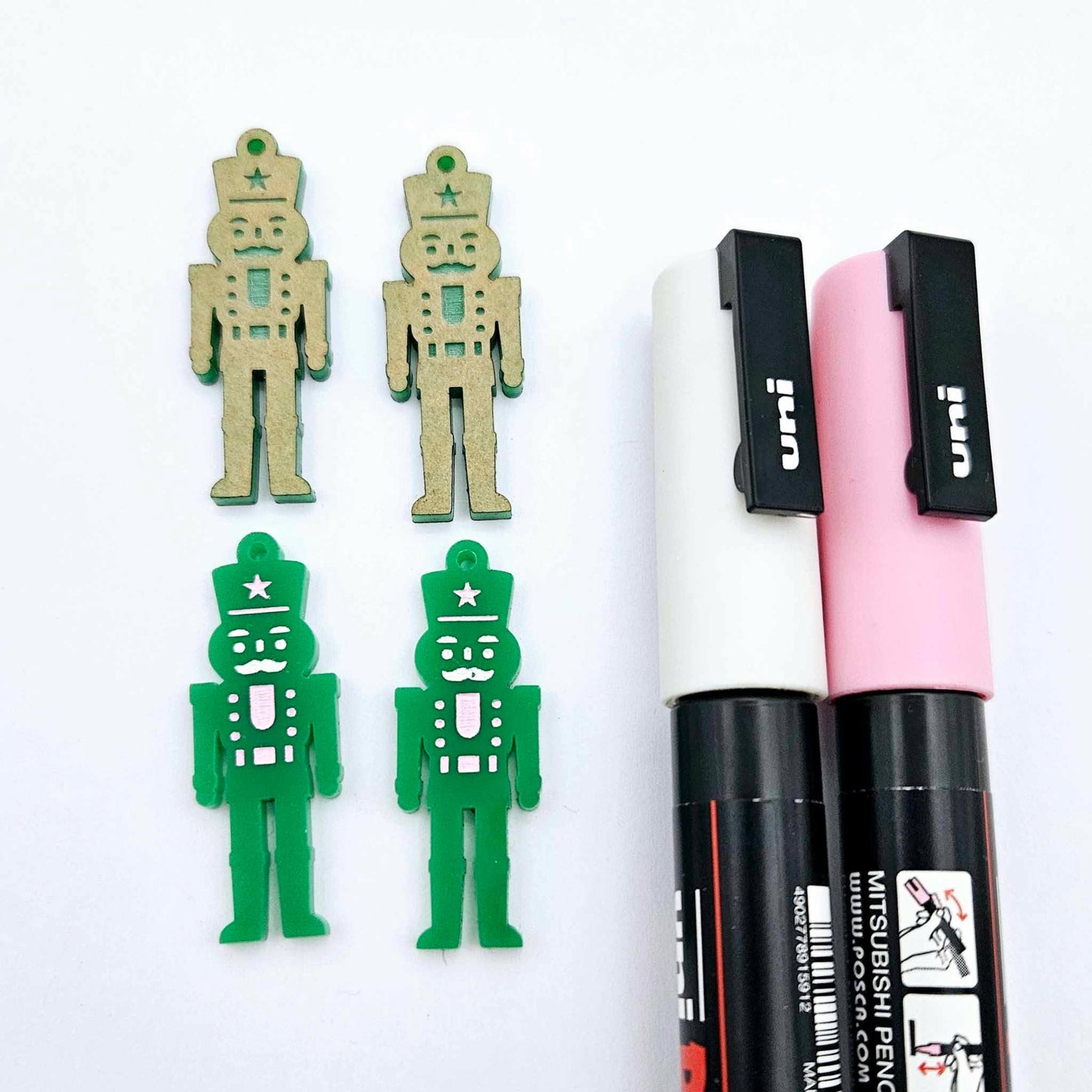 40mm nutcracker Christmas dangle blanks with engraved paint-fill details shown in  green acrylic with pink and white posca paint pens