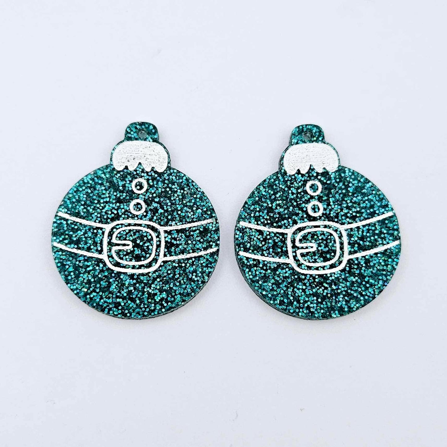 One pair of teal glitter Santa bauble dangle blanks with engraved Santa belt and button details paint filled white, shown laying flat