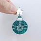 One teal glitter Santa bauble dangle with engraved Santa belt and button details paint filled white, assembled with a 16mm silver mirror star topper