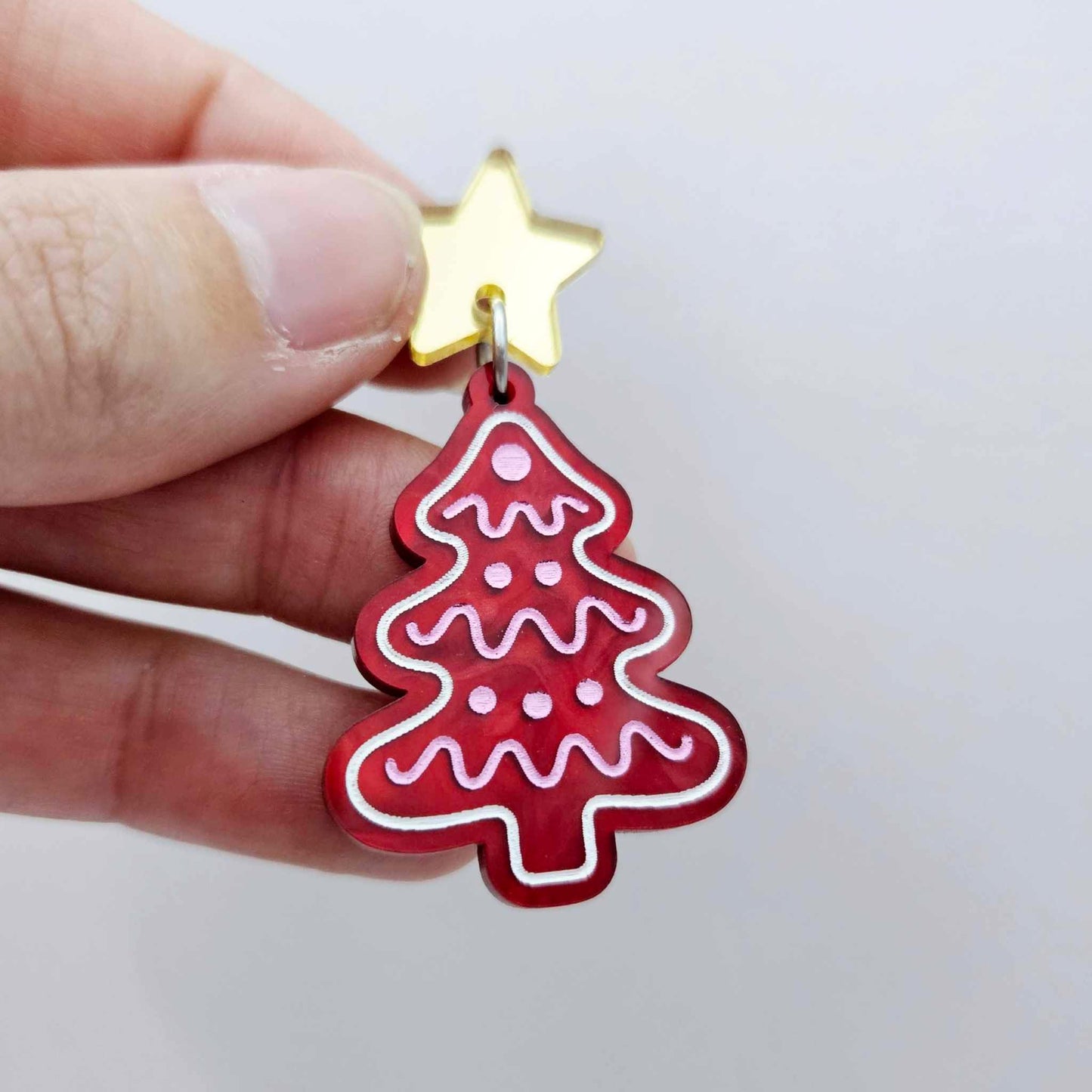 One deep red marble cookie Christmas tree dangle with engraved icing details paint filled in light pink and white, assembled with a 16mm gold mirror star topper