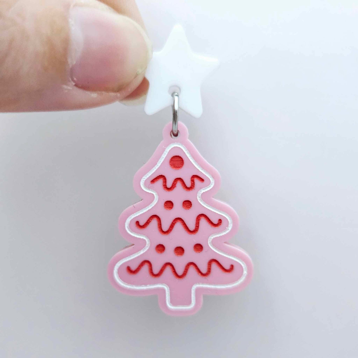 One pastel pink cookie Christmas tree dangle with engraved icing details paint filled in red and white, assembled with a 16mm white star topper