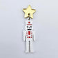 Assembled 40mm nutcracker Christmas dangle earrings in white acrylic with engraved detail paint filled with red and black