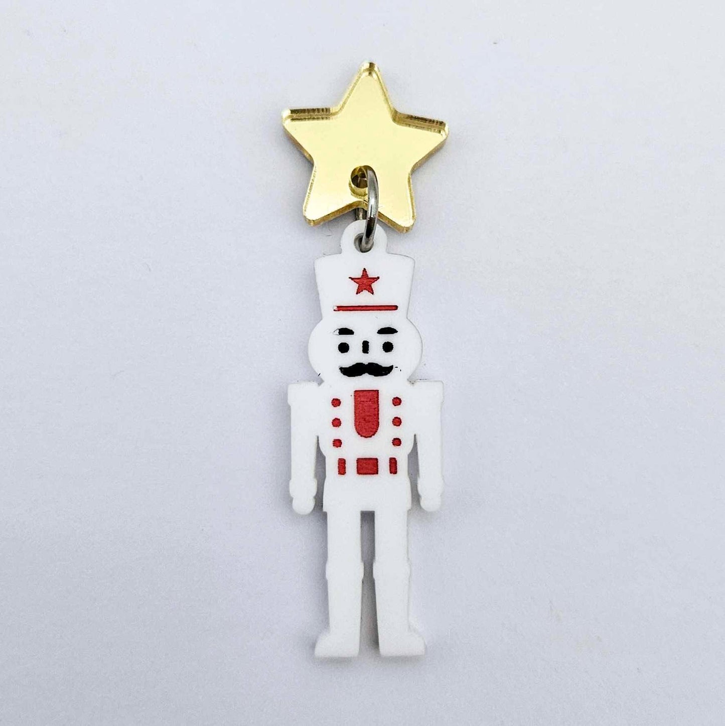 Assembled 40mm nutcracker Christmas dangle earrings in white acrylic with engraved detail paint filled with red and black