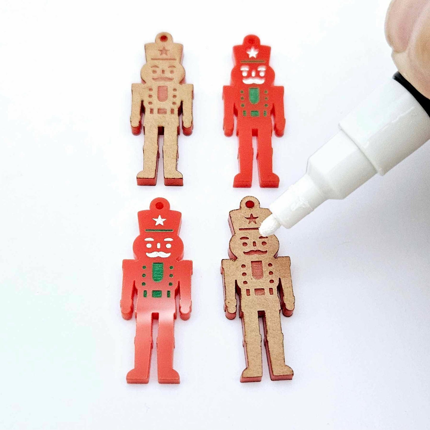 40mm nutcracker Christmas dangle blanks with engraved paint-fill details shown in  red acrylic with white posca paint pens