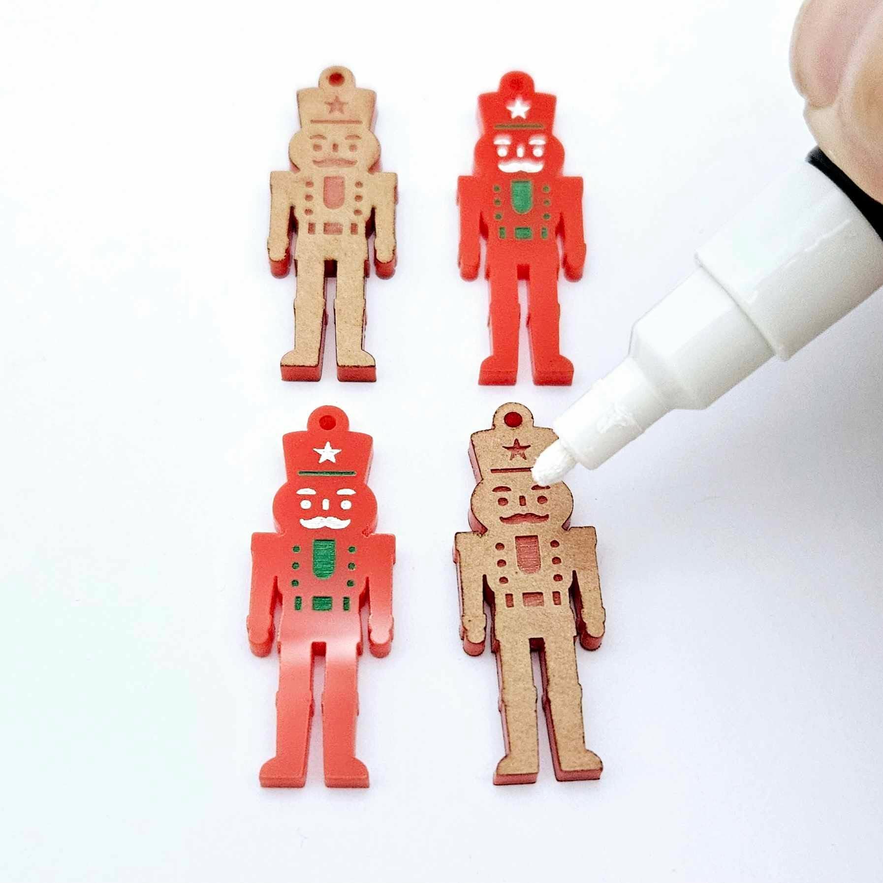 40mm nutcracker Christmas dangle blanks with engraved paint-fill details shown in  red acrylic with white posca paint pens