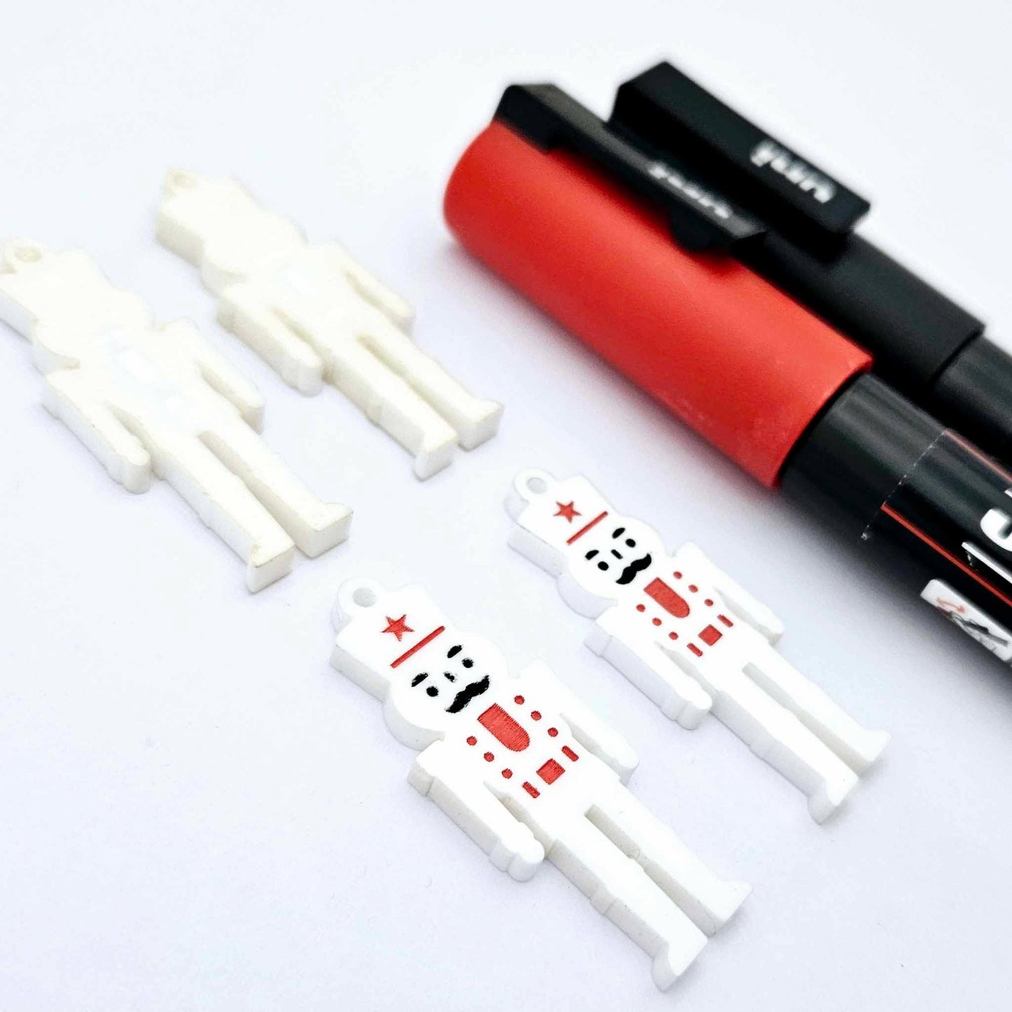 40mm nutcracker Christmas dangle blanks with engraved paint-fill details shown in  white acrylic with black and red posca paint pens