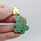 One green marble cookie Christmas tree dangle with engraved icing details paint filled in light pink and white, assembled with a 16mm gold mirror star topper
