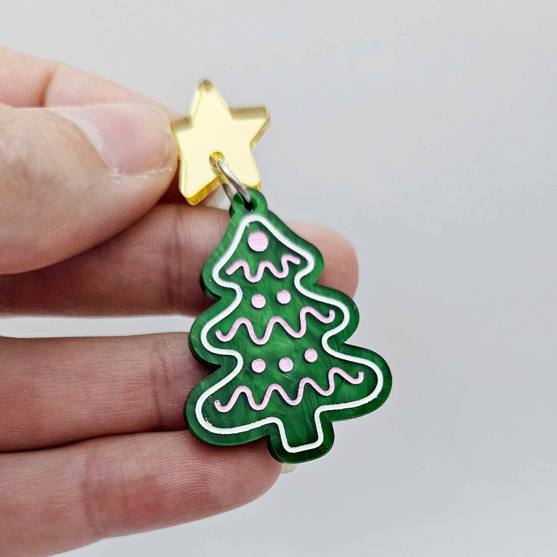 One green marble cookie Christmas tree dangle with engraved icing details paint filled in light pink and white, assembled with a 16mm gold mirror star topper