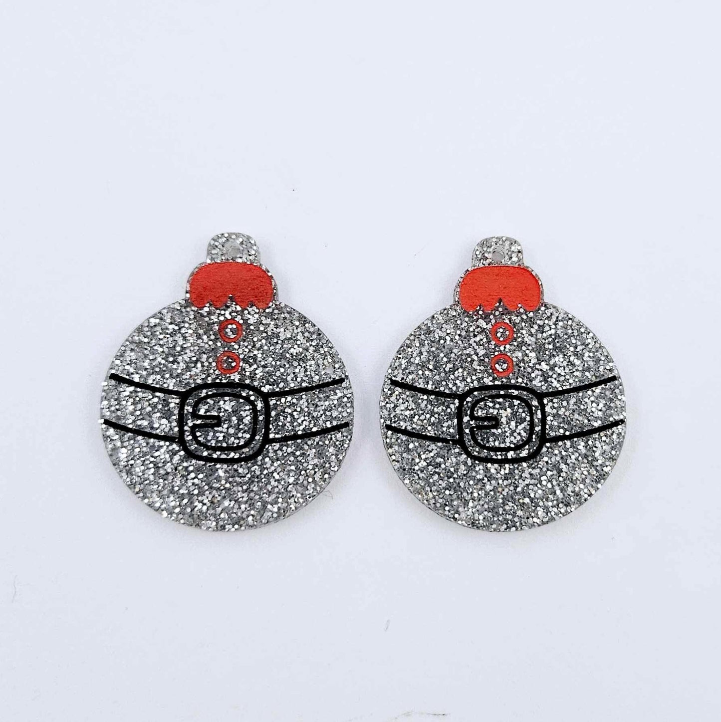 One pair of silver glitter Santa bauble dangle blanks with engraved Santa belt and button details paint filled red and black, shown laying flat