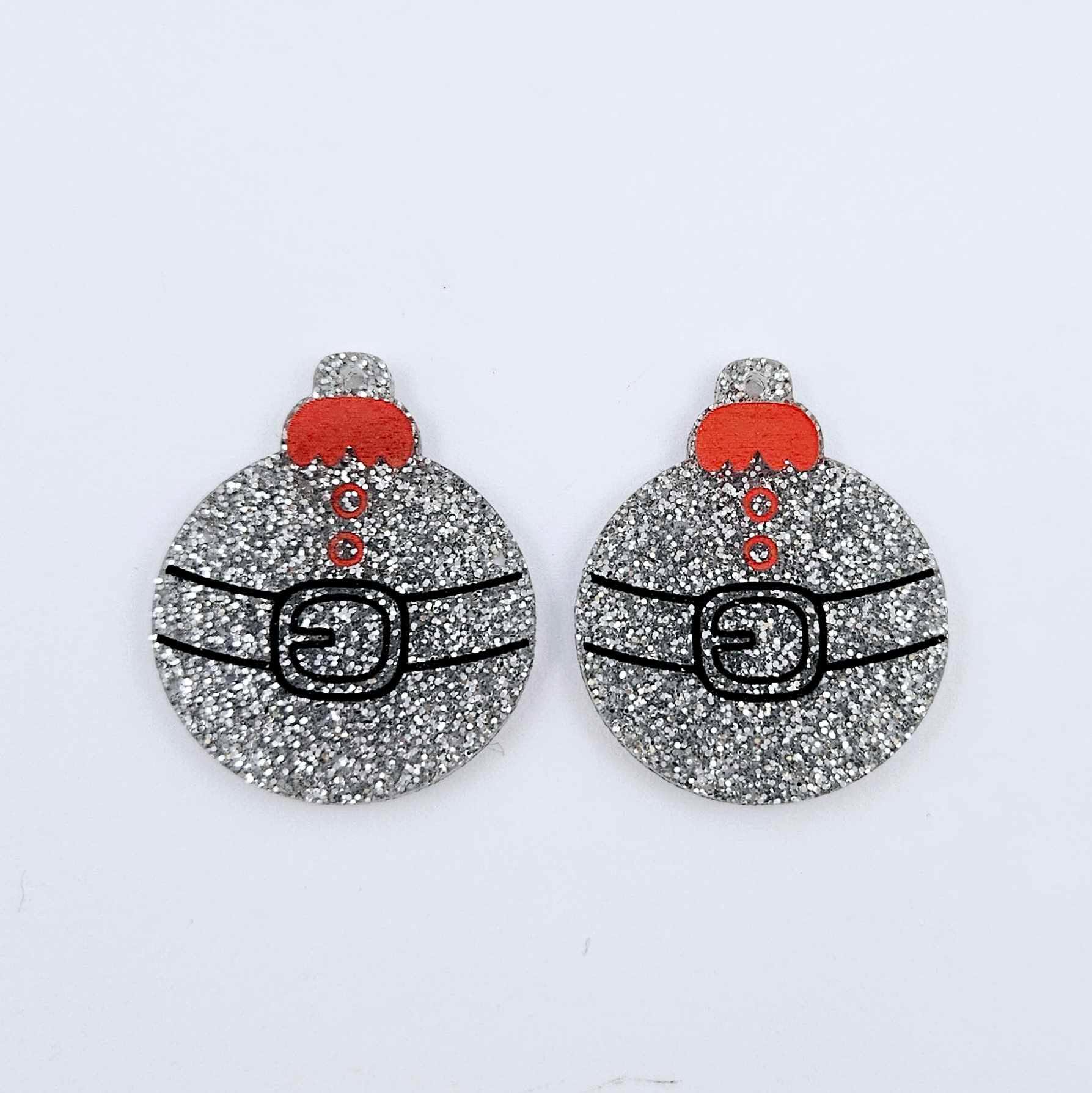 One pair of silver glitter Santa bauble dangle blanks with engraved Santa belt and button details paint filled red and black, shown laying flat