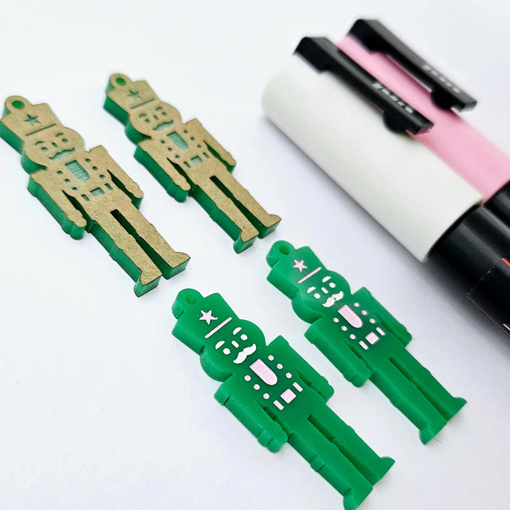 40mm nutcracker Christmas dangle blanks with engraved paint-fill details shown in  green acrylic with pink and white posca paint pens