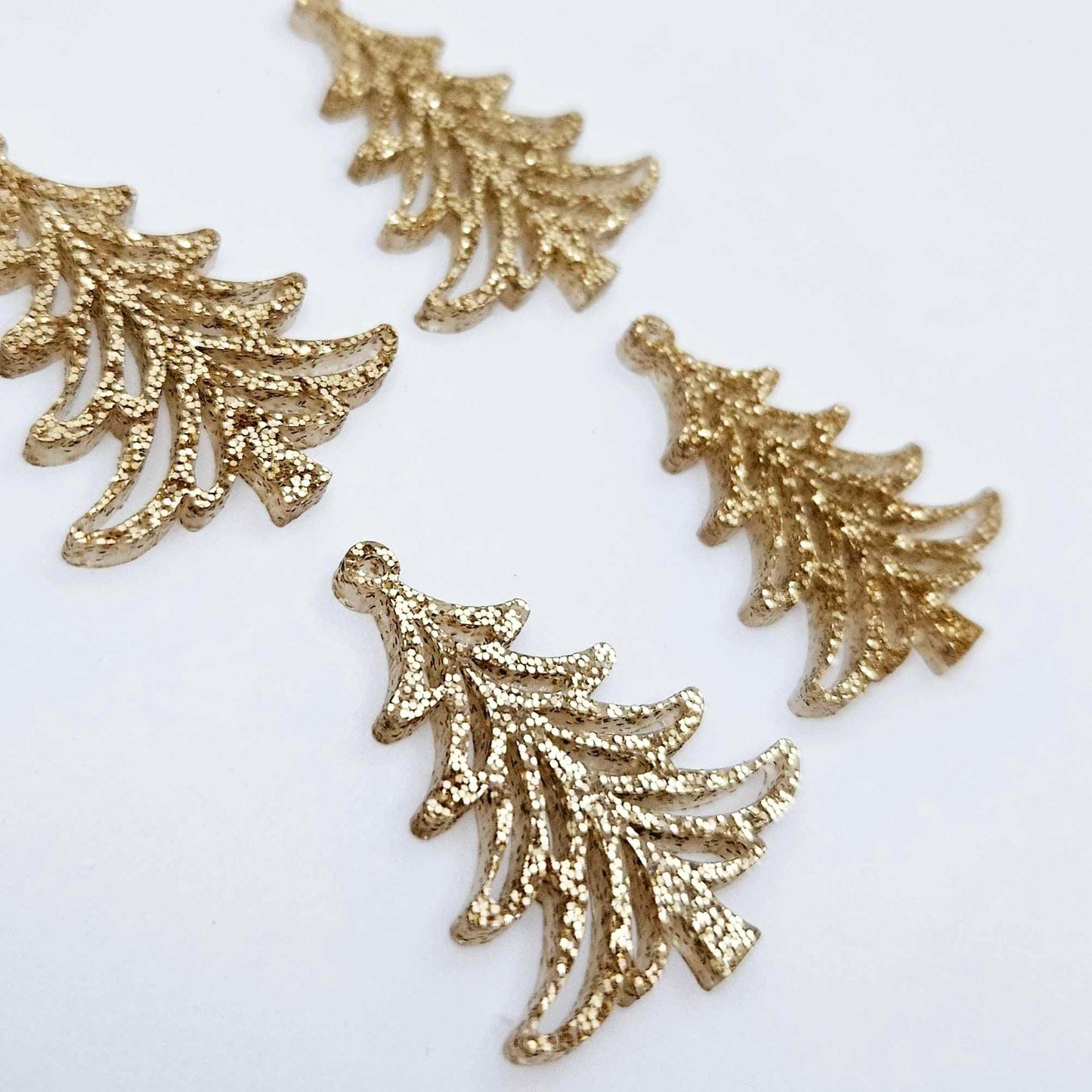 Two pairs of 35mm rose gold glitter Cascade Christmas Tree dangle earring blanks laying flat on a white background