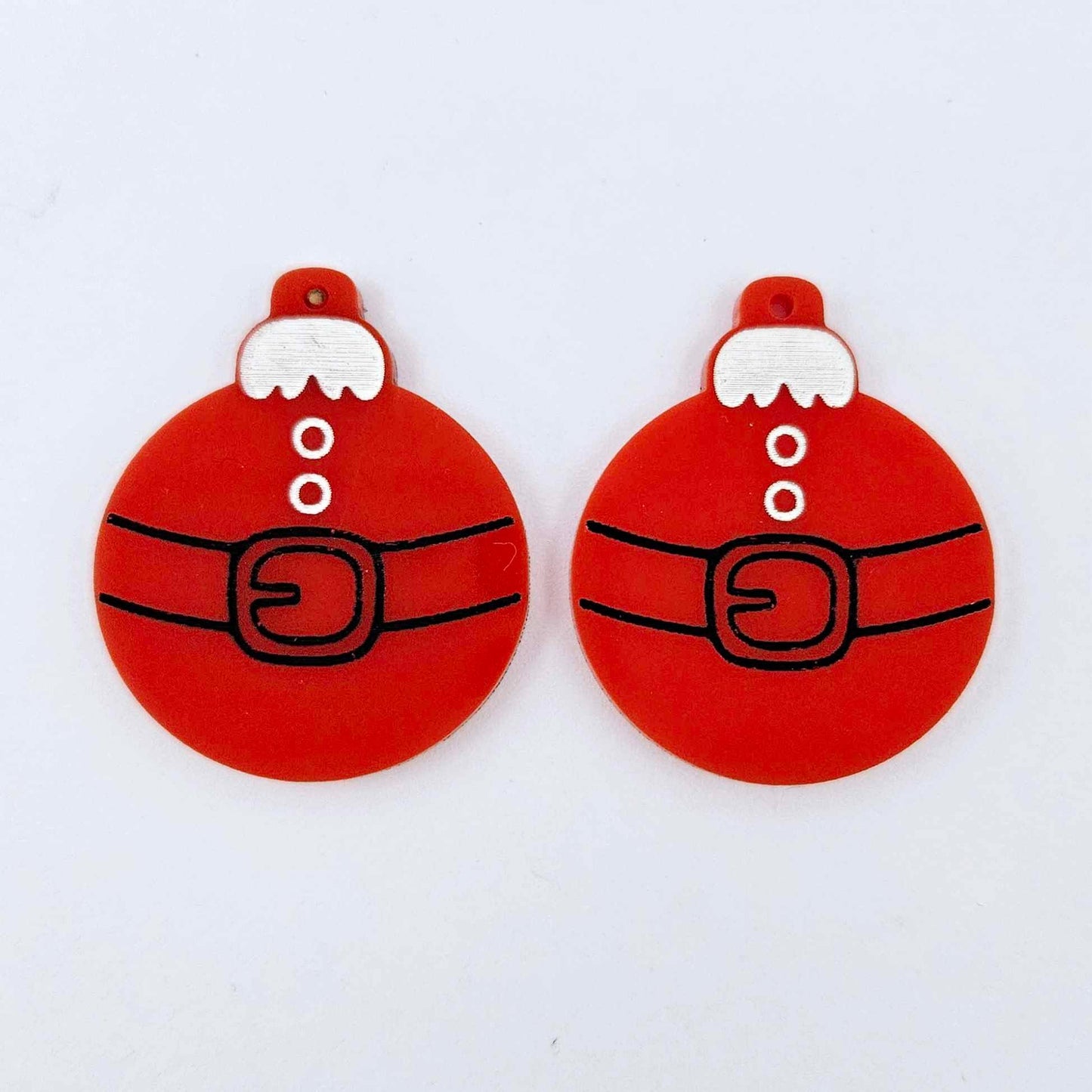 One pair of solid red Santa bauble dangle blanks with engraved Santa belt and button details paint filled in black and white, shown laying flat