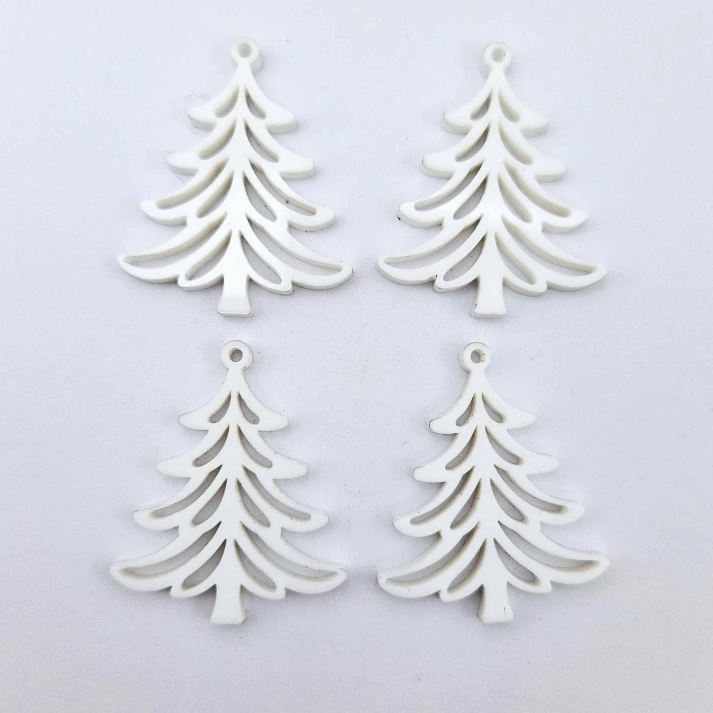 Two pairs of 35mm white acrylic Cascade Christmas Tree dangle blanks laying flat on a white background