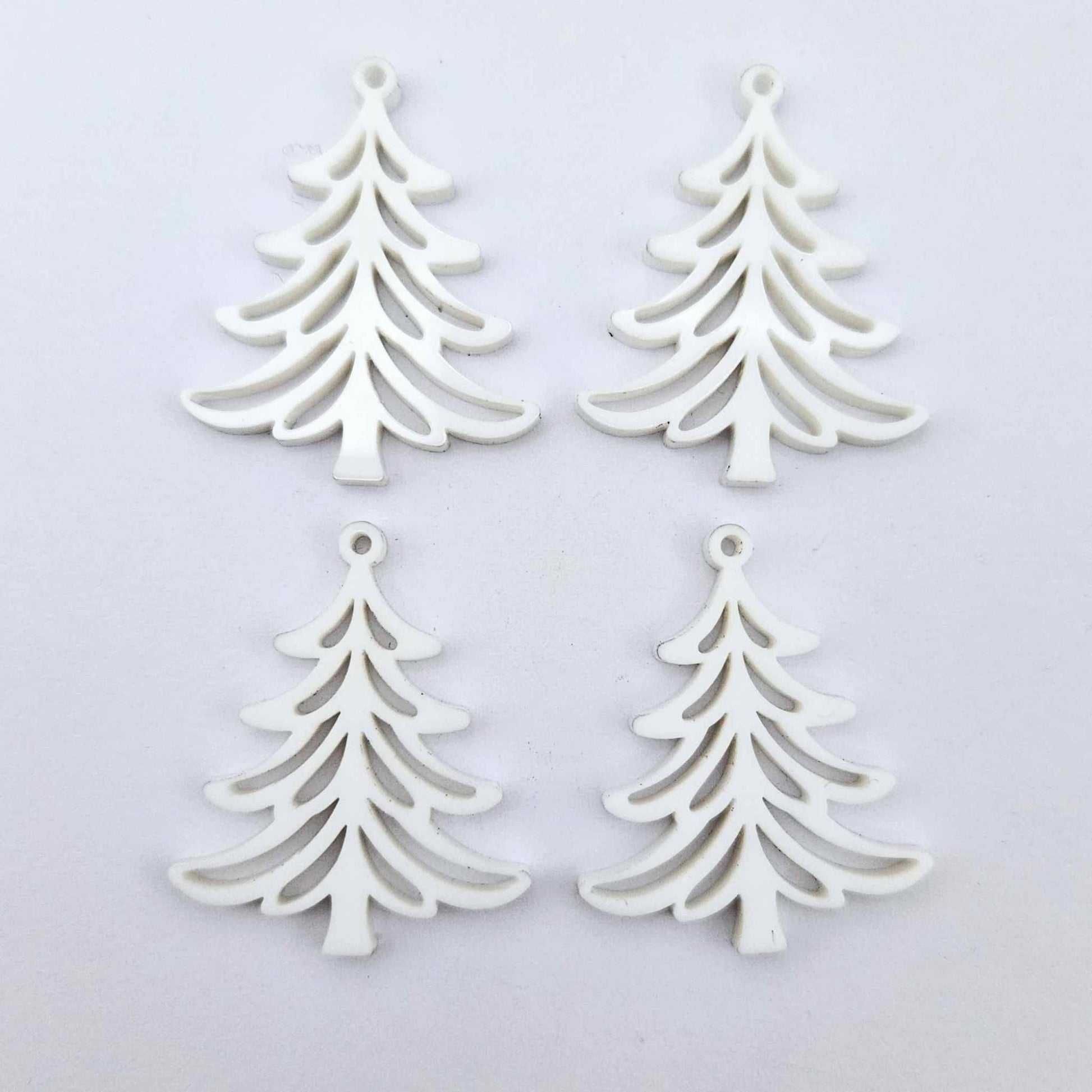 Two pairs of 35mm white acrylic Cascade Christmas Tree dangle blanks laying flat on a white background