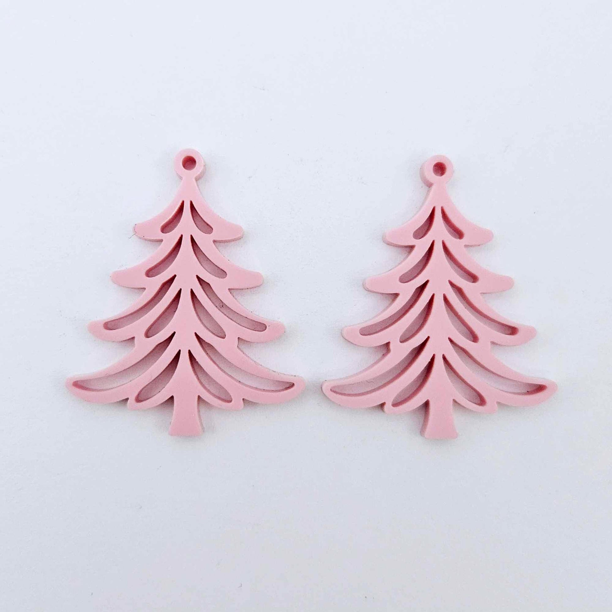 One pair of 35mm pastel pink acrylic Cascade Christmas Tree dangle earring blanks laying flat on a white background