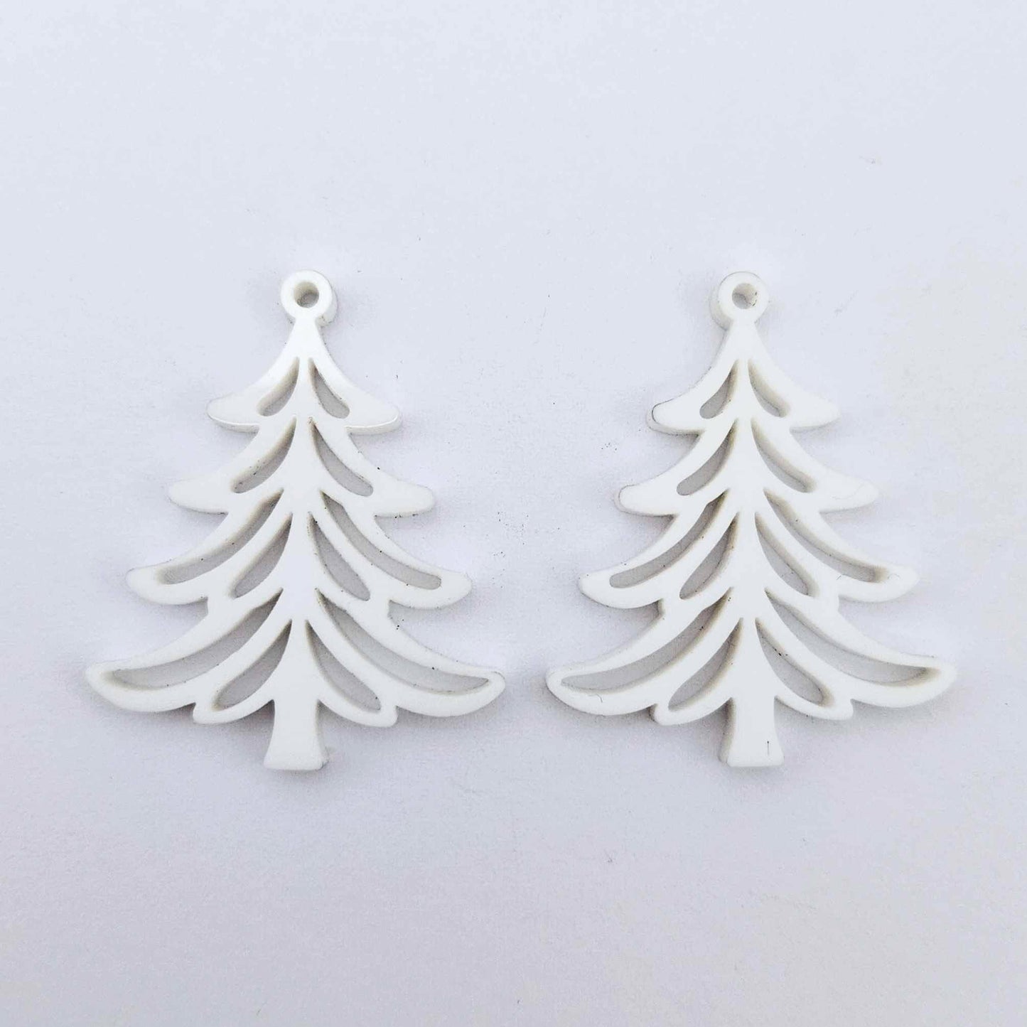 One pair of 35mm white acrylic Cascade Christmas Tree dangle blanks laying flat on a white background.