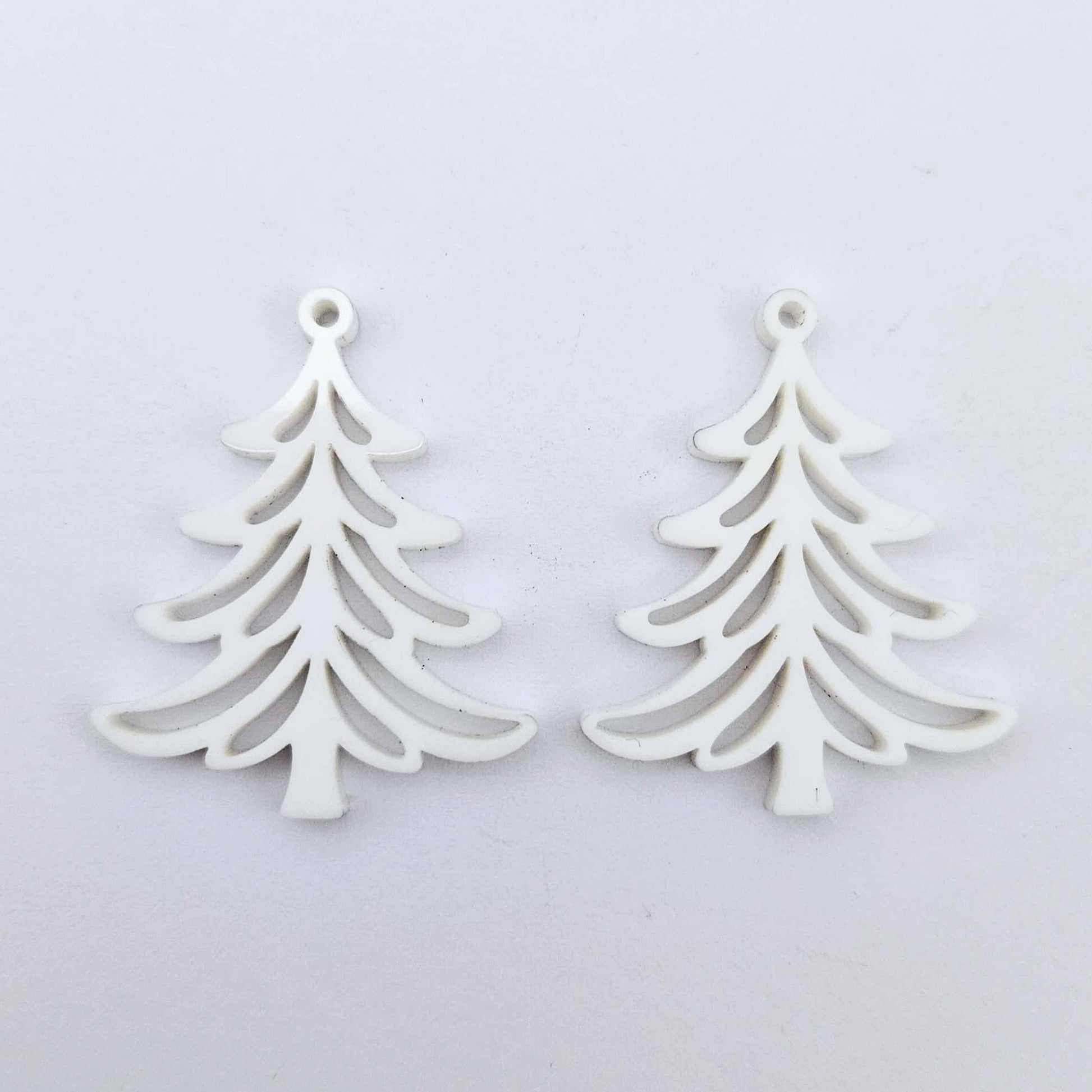 One pair of 35mm white acrylic Cascade Christmas Tree dangle blanks laying flat on a white background.