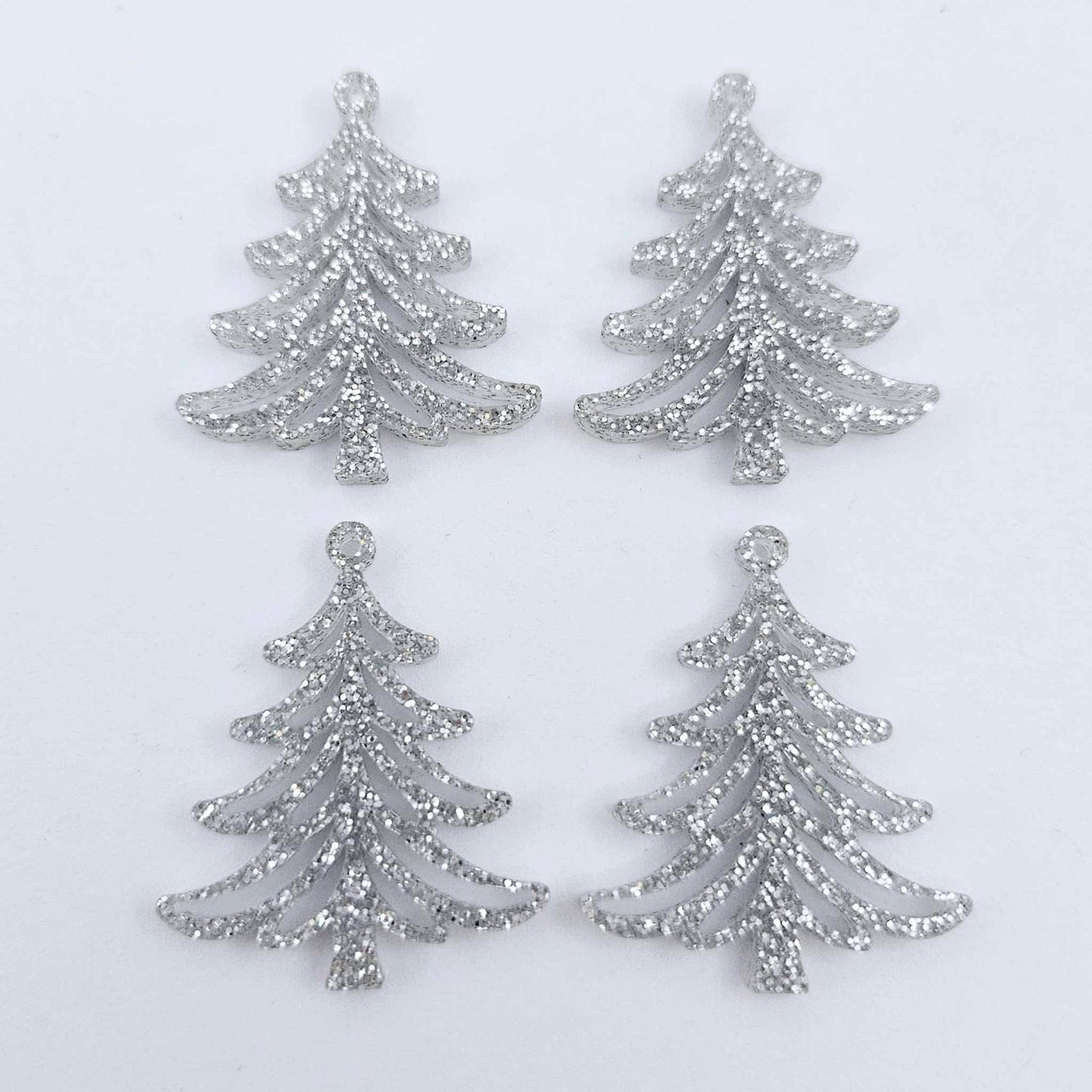 Two pairs of 35mm silver glitter acrylic Cascade Christmas Tree dangle earring blanks laying flat on a white background