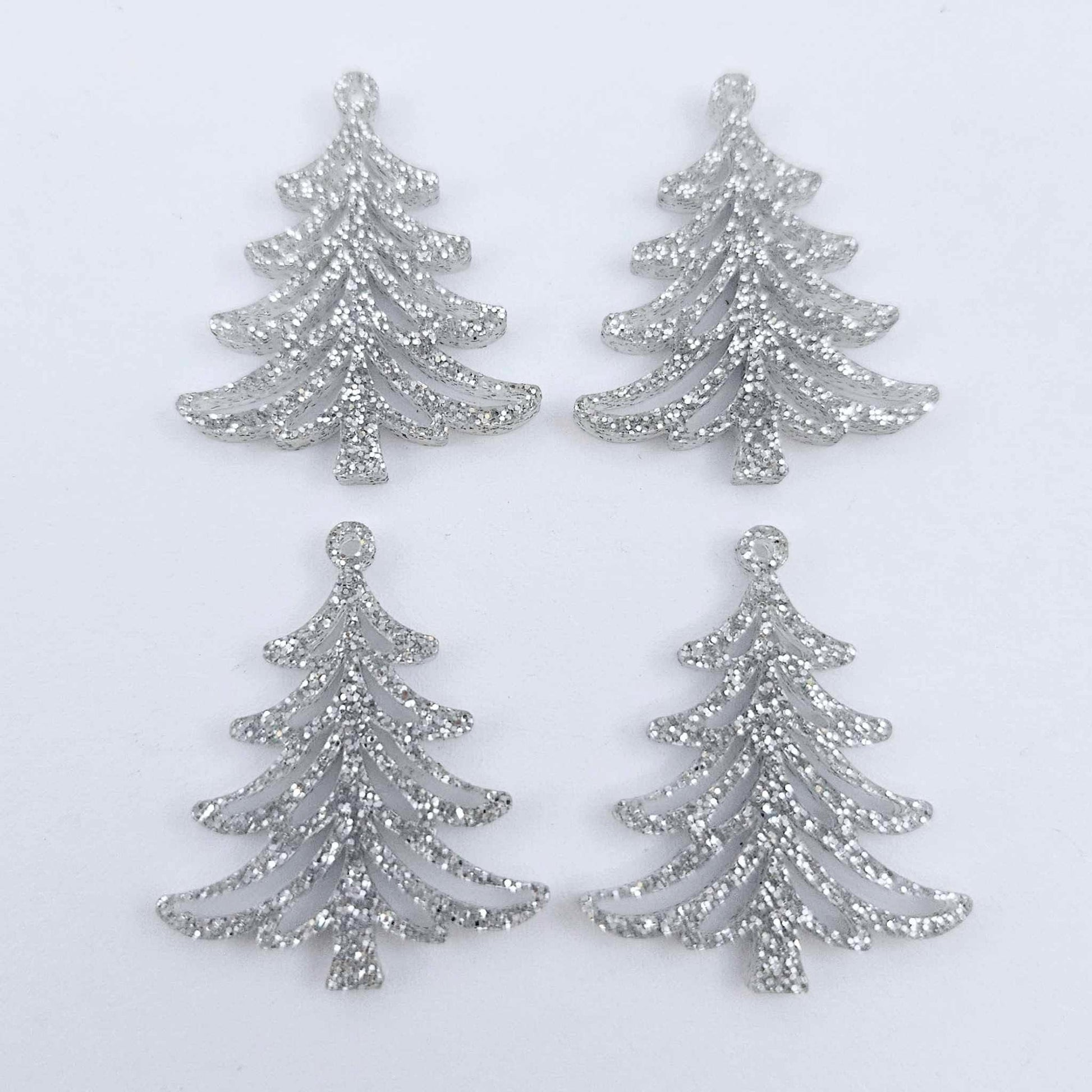 Two pairs of 35mm silver glitter acrylic Cascade Christmas Tree dangle earring blanks laying flat on a white background