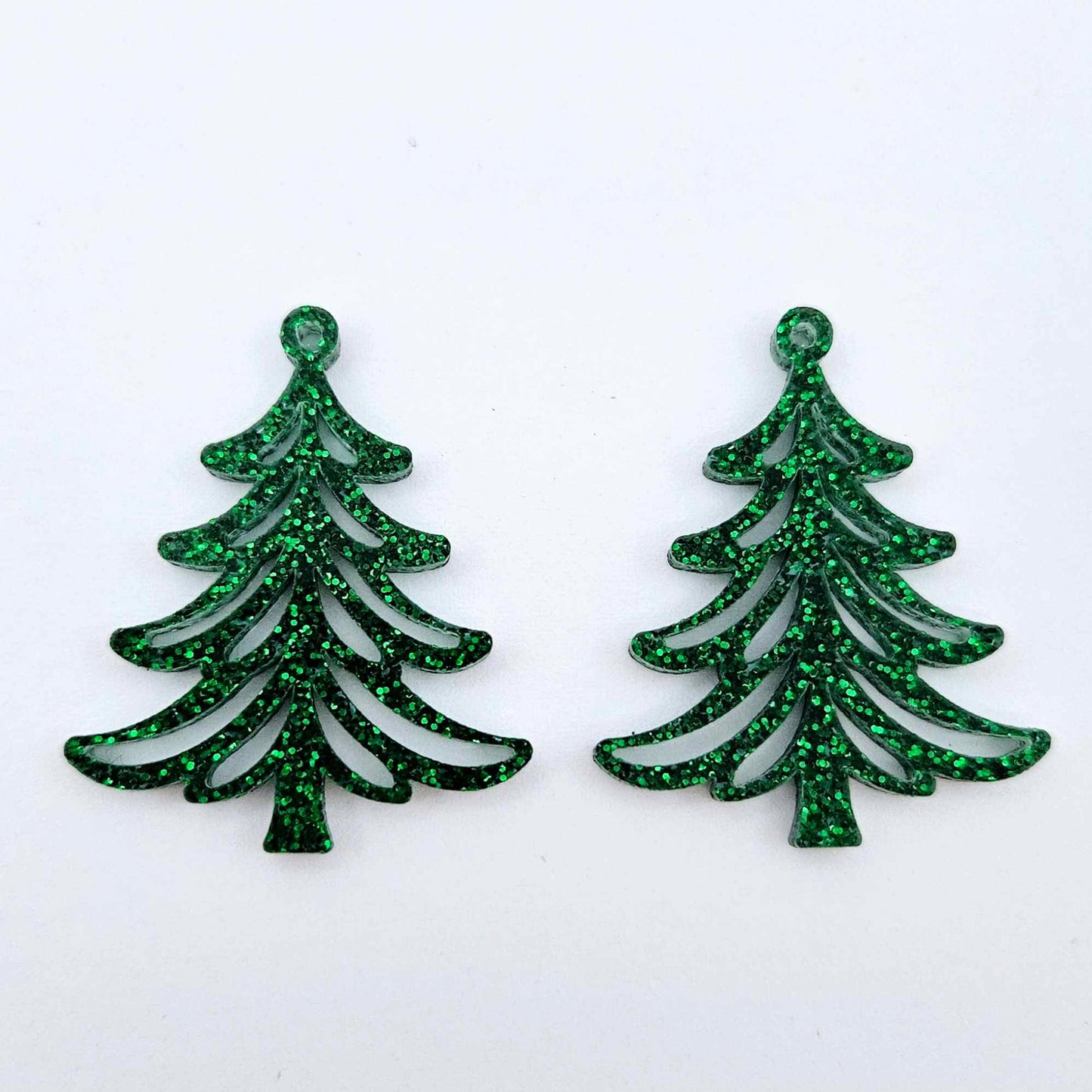 One pair of 35mm green glitter acrylic Cascade Christmas Tree dangle earring blanks laying flat on a white background.
