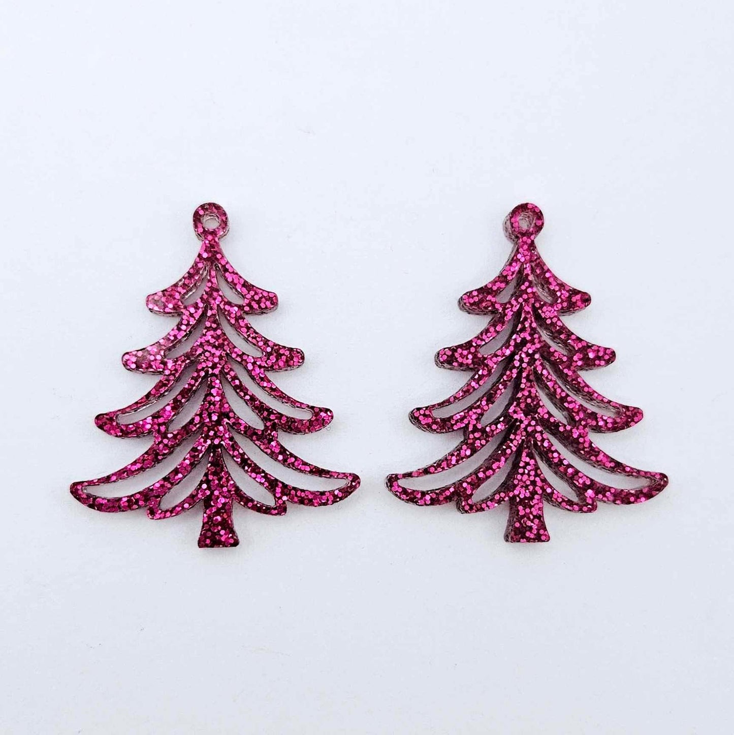 One pair of 35mm hot pink glitter Cascade Christmas Tree dangle earring blanks laying flat on a white background