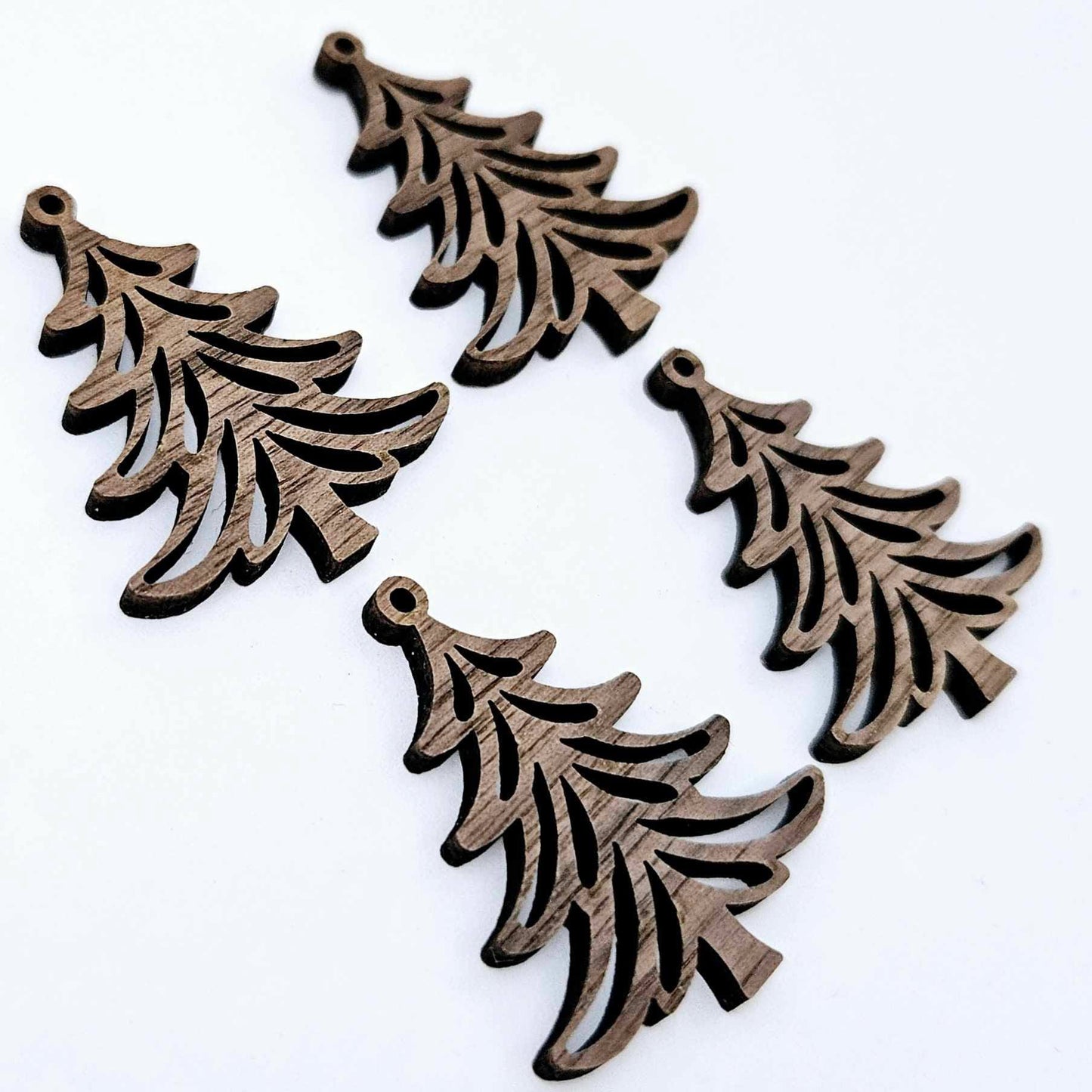 Two pairs of 35mm walnut veneer Cascade Christmas Tree dangle earring blanks laying flat on a white background