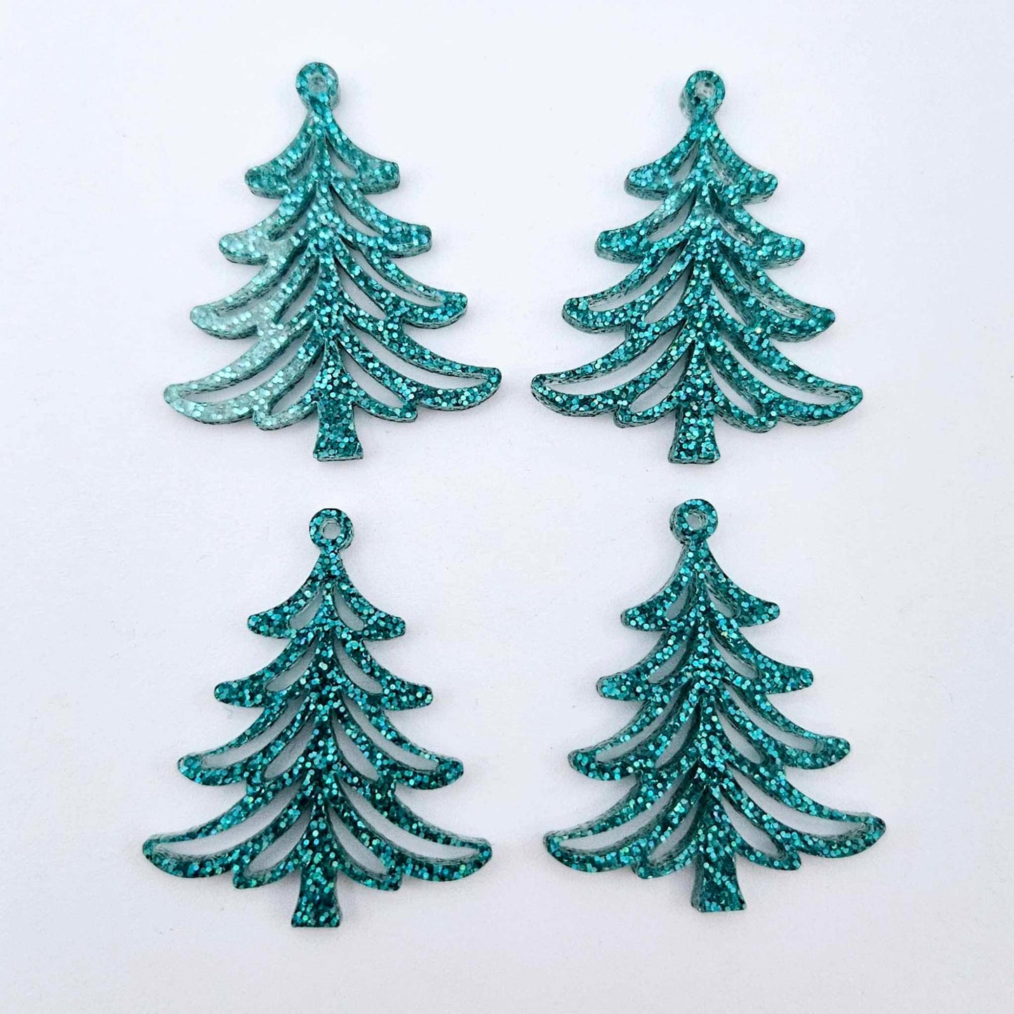 Two pairs of 35mm teal glitter acrylic Cascade Christmas Tree dangle earring blanks laying flat on a white background