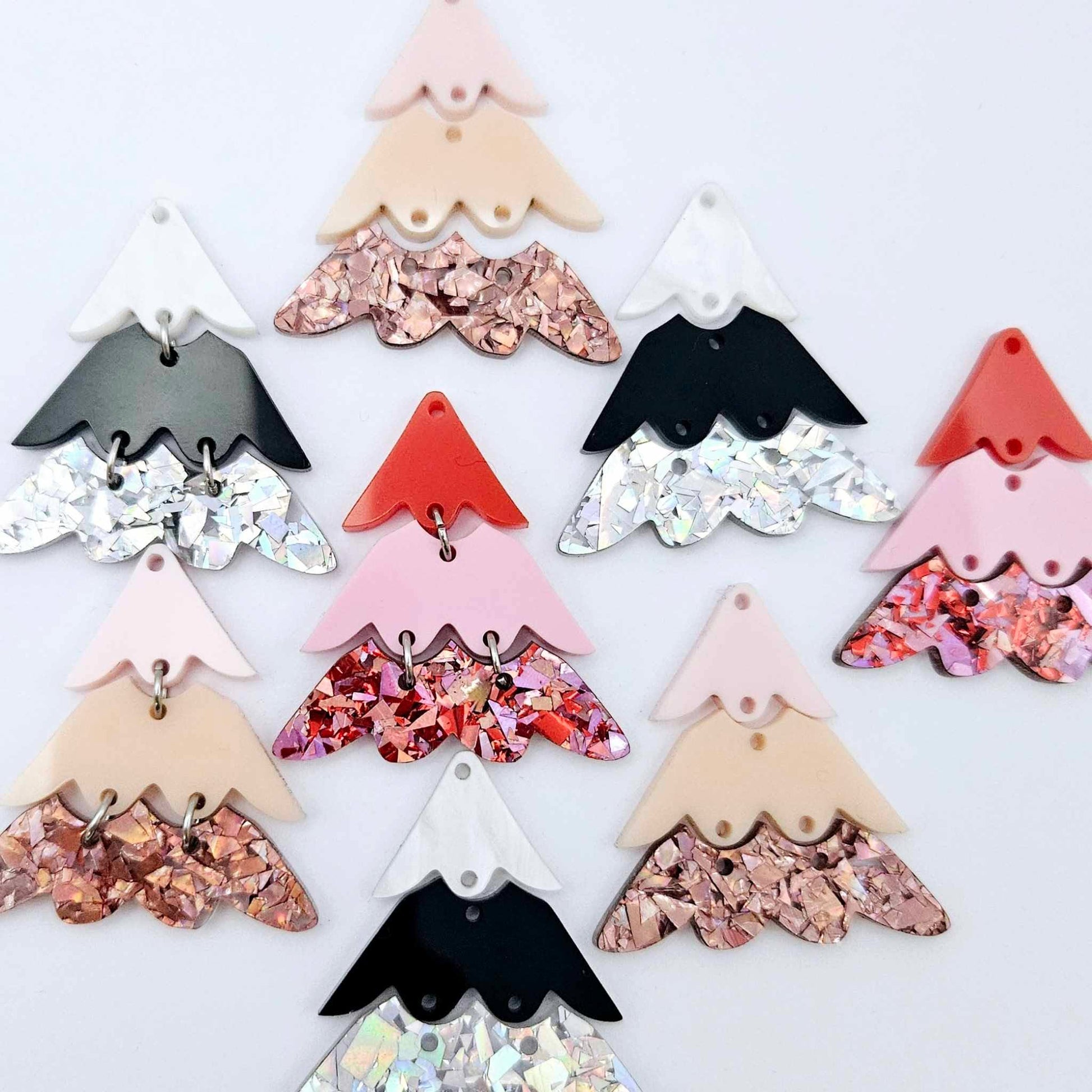 A mixture of the three non-traditional 40mm three piece Christmas Tree dangle earring blank designs laying flat on a white background