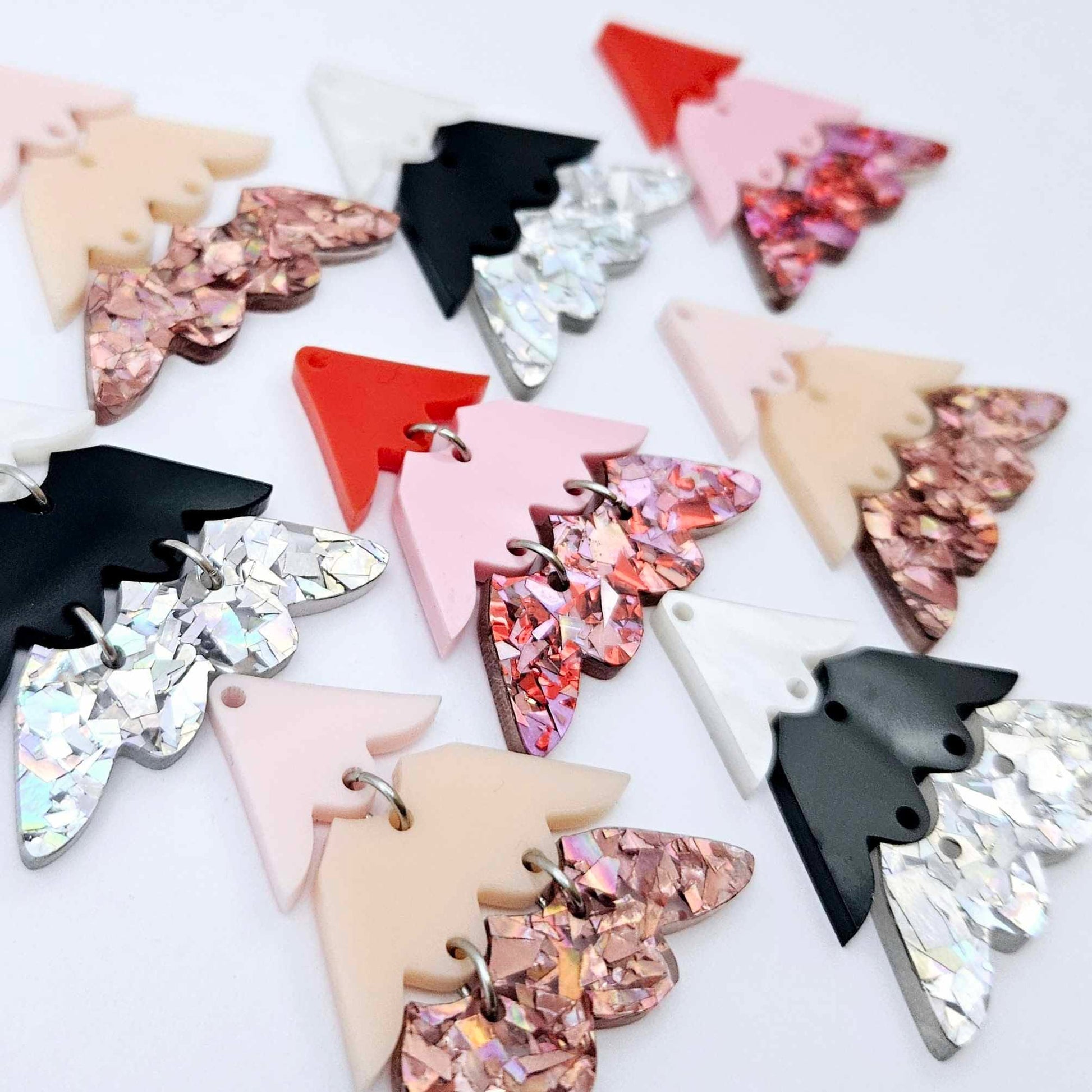 A mixture of the three non-traditional 40mm three piece Christmas Tree dangle earring blank designs laying flat on a white background