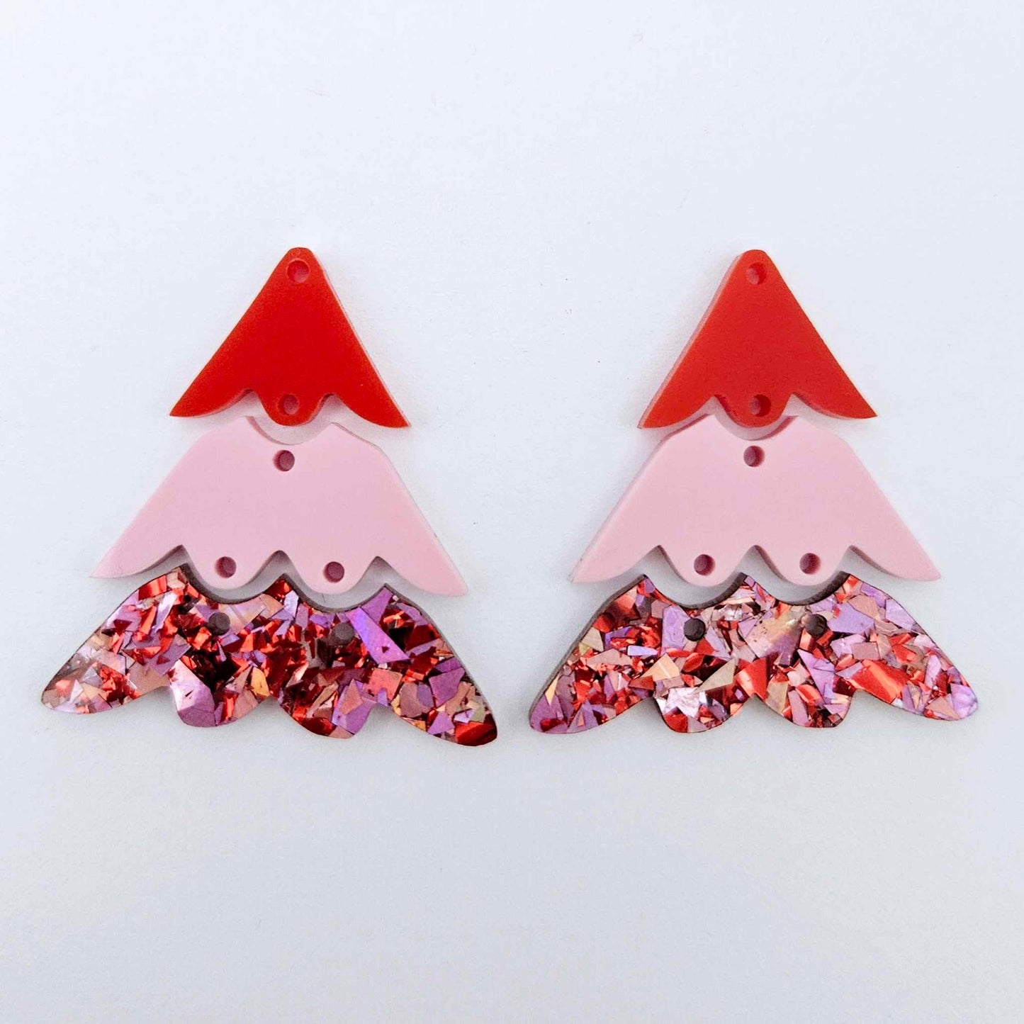 One pair of 40mm three piece Christmas Tree dangle earring blanks in Chunky Love Glitter, Pastel Pink and Solid Red acrylic laying flat on a white background