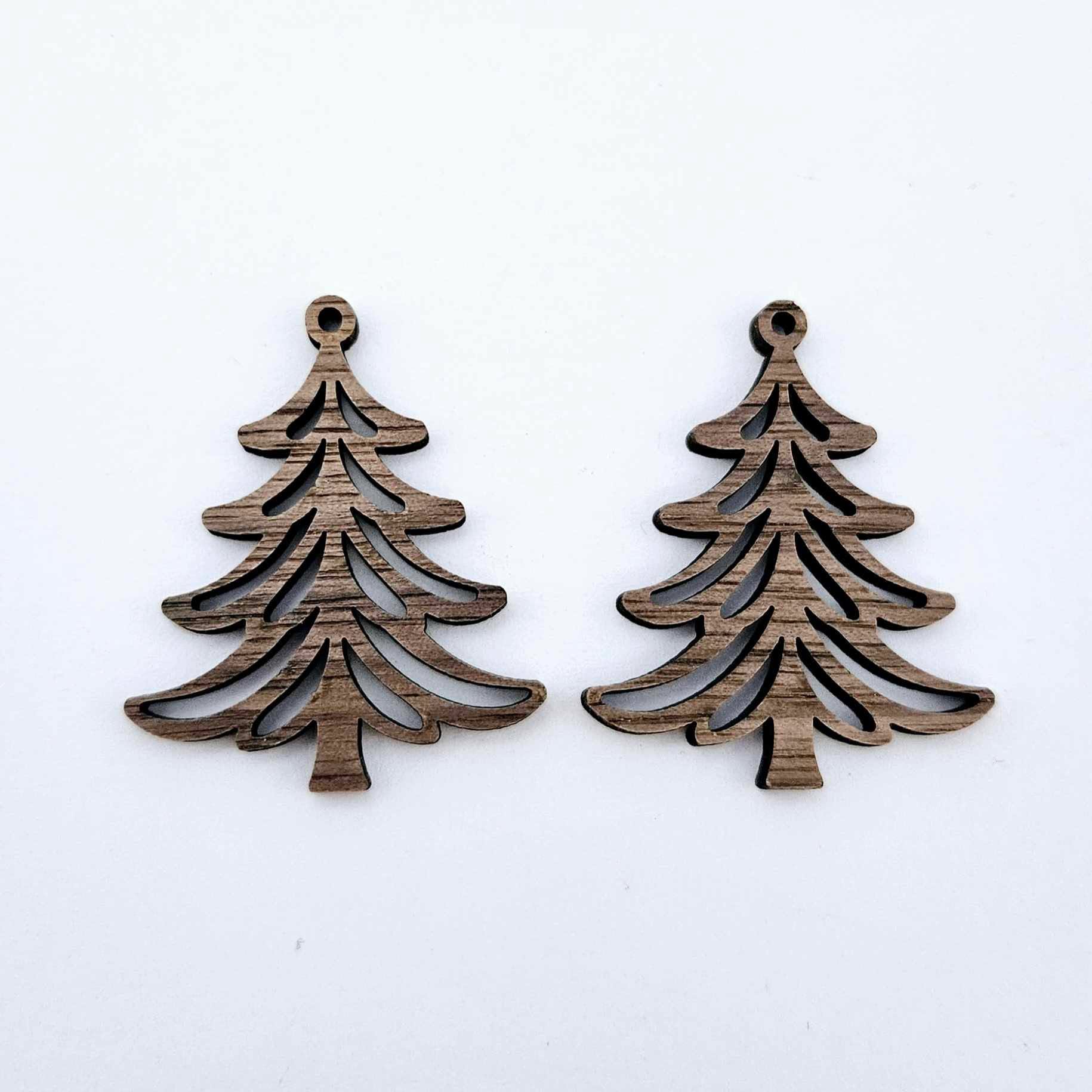 One pair of 35mm walnut veneer Cascade Christmas Tree dangle earring blanks laying flat on a white background
