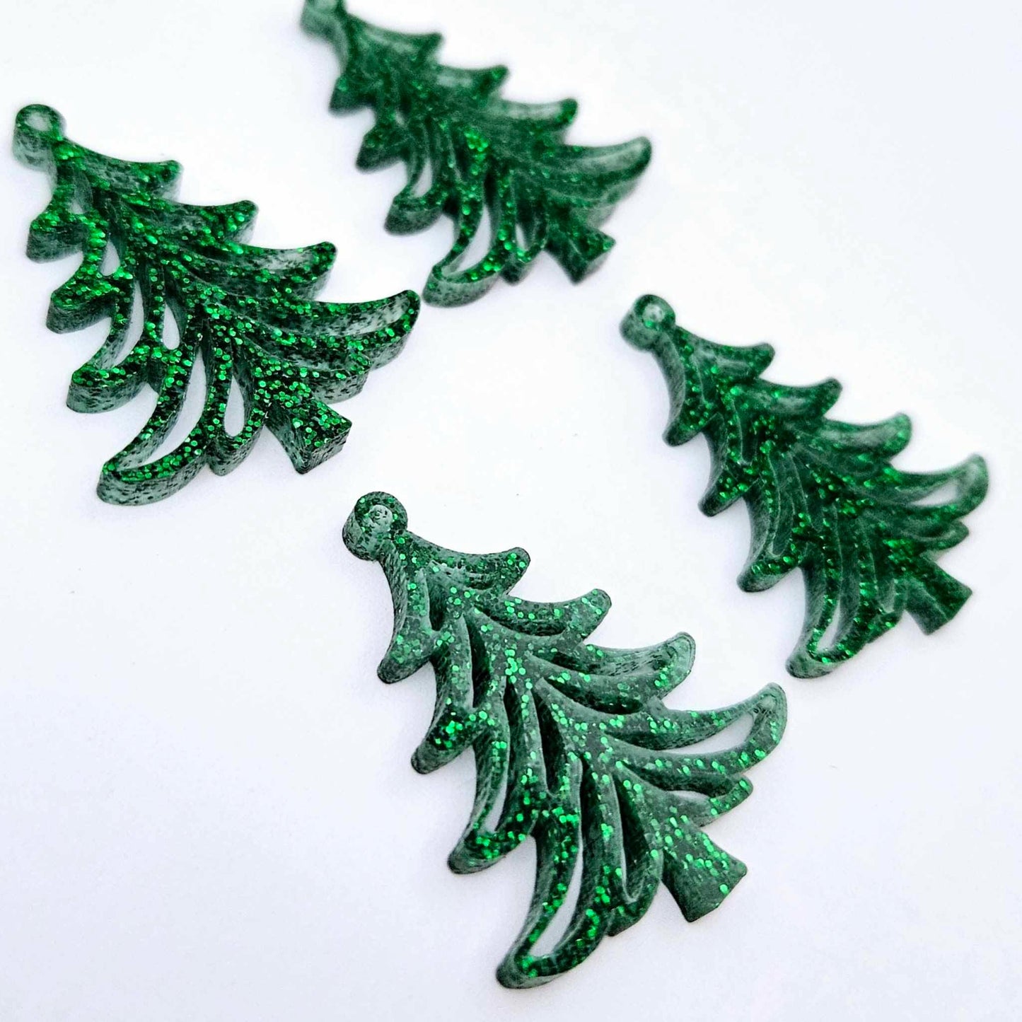 Two pairs of 35mm green glitter acrylic Cascade Christmas Tree dangle earring blanks laying flat on a white background.
