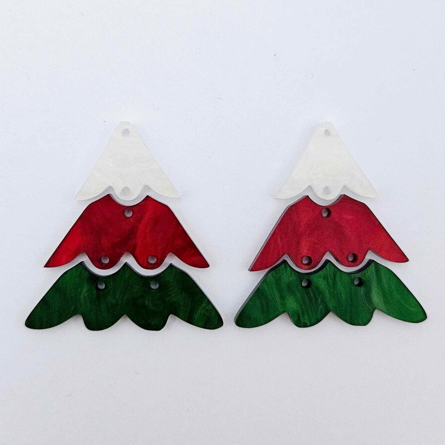 One pair of 40mm three piece Christmas Tree dangle earring blanks in green marble, red marble and white marble acrylic laying flat on a white background