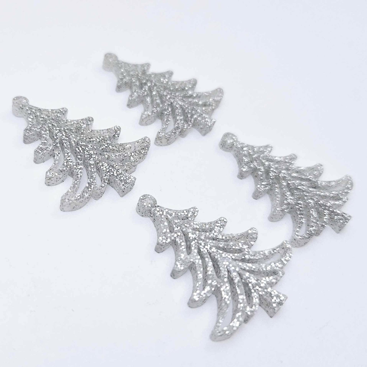 Two pairs of 35mm silver glitter acrylic Cascade Christmas Tree dangle earring blanks laying flat on a white background