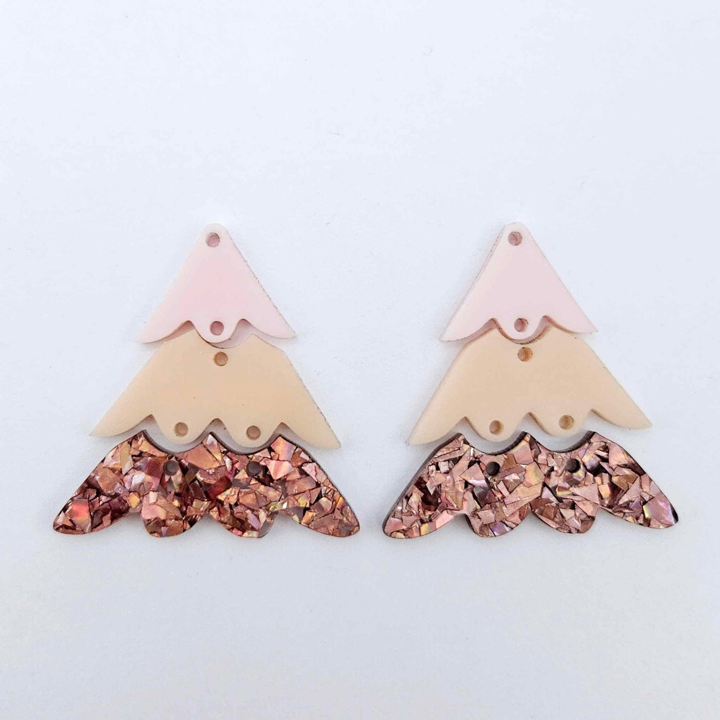 One pair of 40mm three piece Christmas Tree dangle earring blanks in chunky holographic rose gold glitter, peach and strawberry milkshake acrylic laying flat on a white background