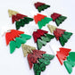 A mixture of the three traditional 40mm three piece Christmas Tree dangle blank designs laying flat on a white background