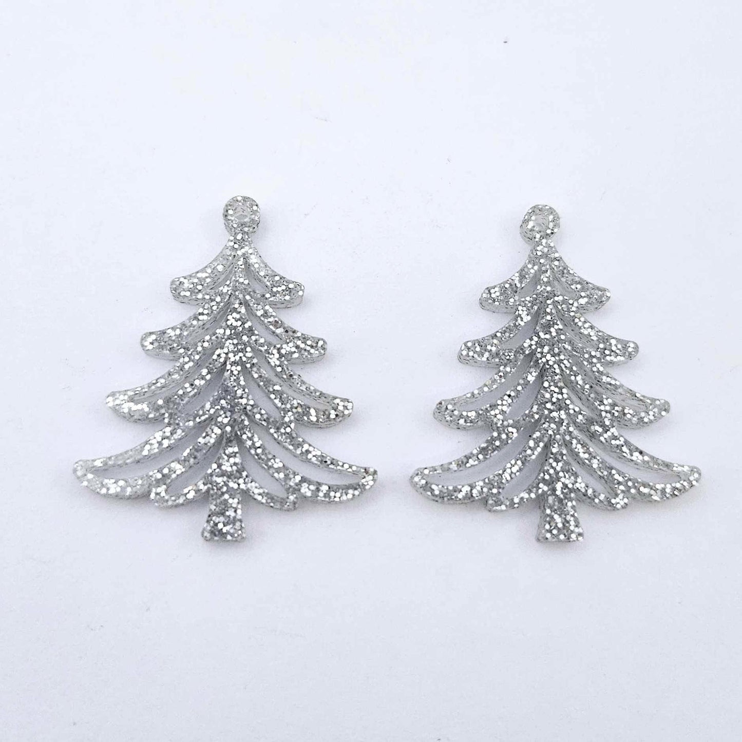 One pair of 35mm silver glitter acrylic Cascade Christmas Tree dangle earring blanks laying flat on a white background