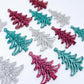 A mixture of hot pink glitter, teal glitter and silver glitter 35mm Cascade Christmas Tree dangle blanks laying flat on a white background