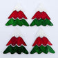 Two pairs of 40mm three piece Christmas Tree dangle earring blanks in green marble, red marble and white marble acrylic laying flat on a white background