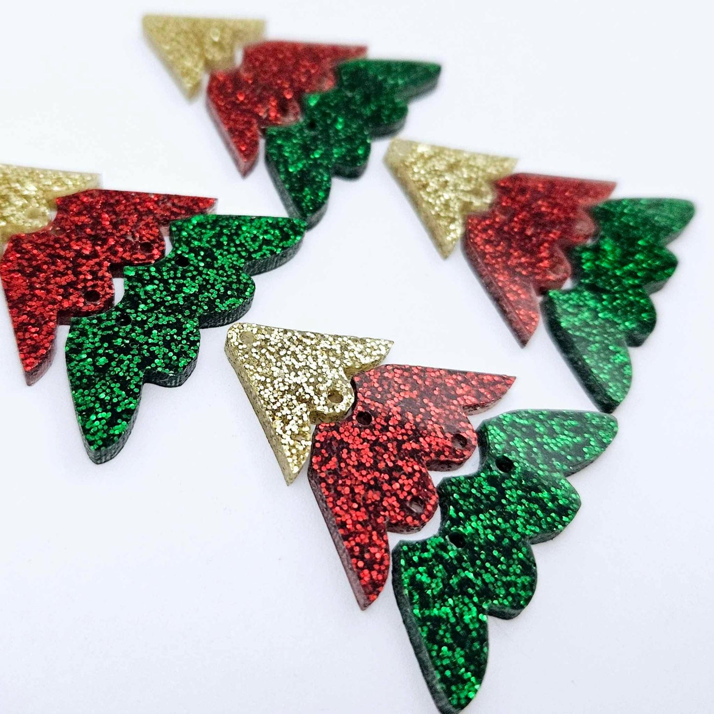 Two pairs of green, red and gold glitter three piece Christmas Tree dangle earring blanks laying flat