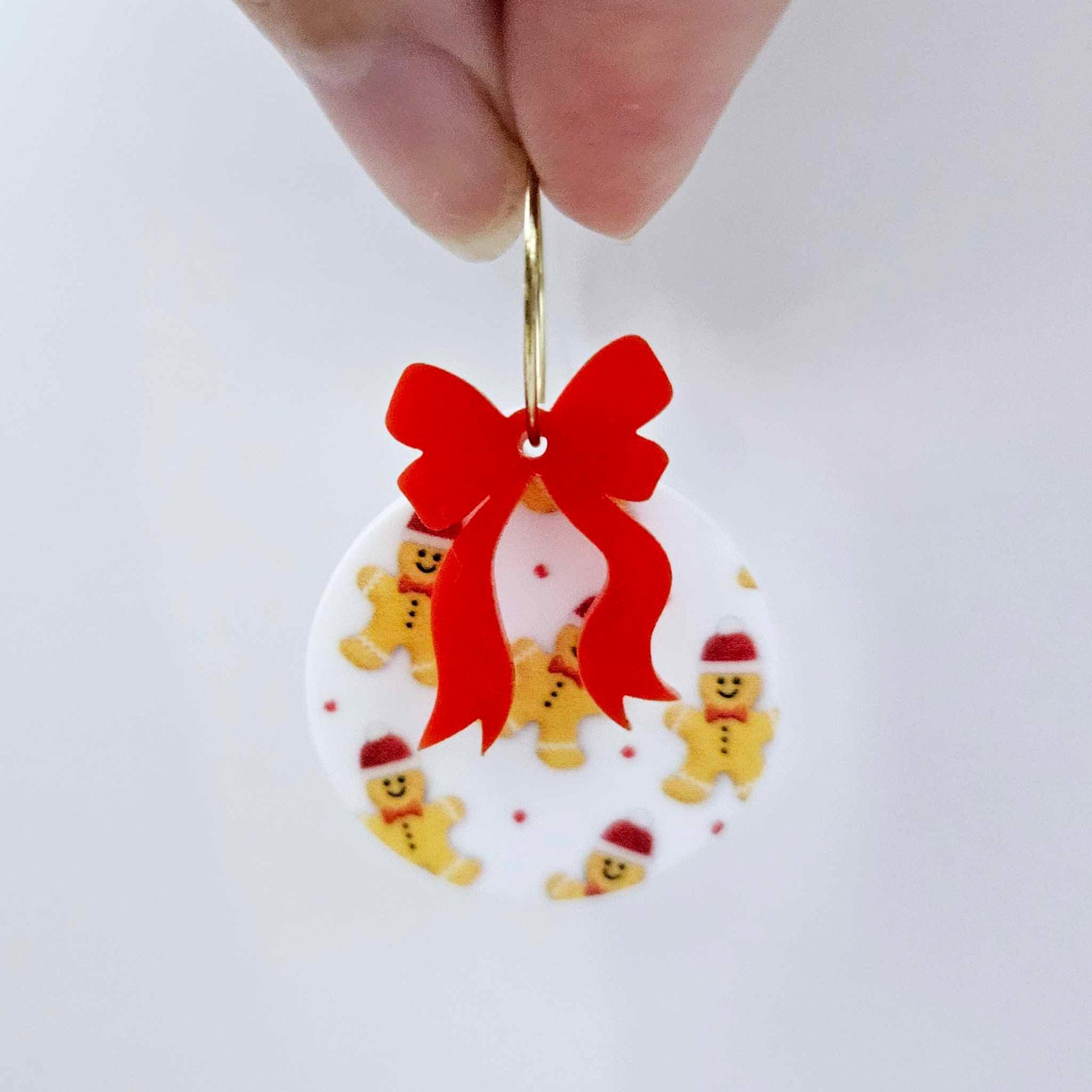 One Gingerbread Party UV printed bauble and included red bow assembled on a 20mm hoop