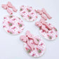 Two pairs of Pink Patchwork UV printed bauble dangle blanks with included pastel pink bows laying flat