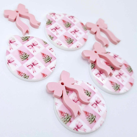Two pairs of Pink Patchwork UV printed bauble dangle blanks with included pastel pink bows laying flat